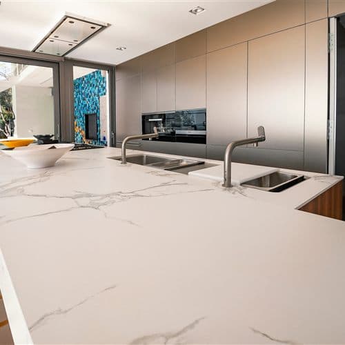 Cocina con isla y encimera de piedra natural en San Cibrao das Viñas