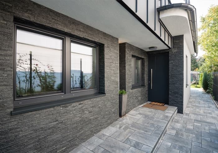 Vivienda unifamiliar con fachada revestida de piedra a medida en San Cibrao das Viñas