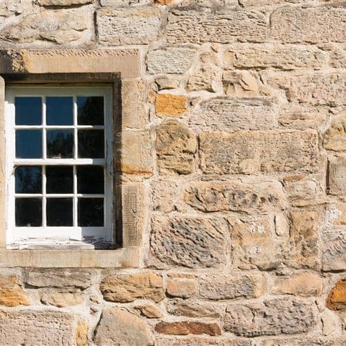 Fachada revestida de piedra natural con recercado de ventana en San Cibrao das Viñas